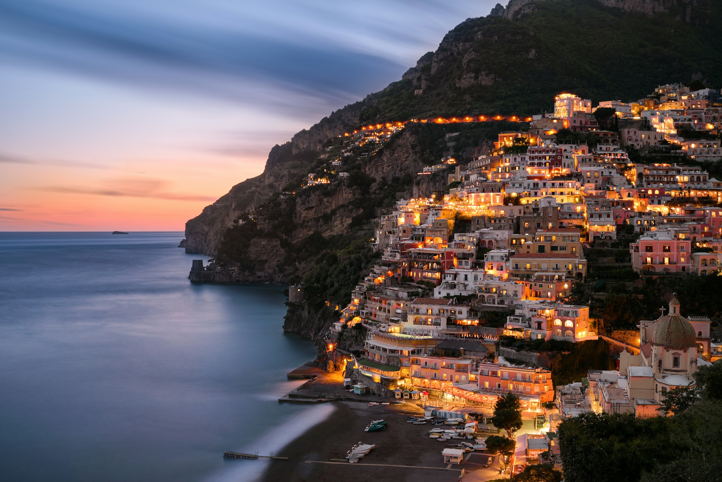 City view of Positano in the evening blue hour. Italian village on the beautiful mediterranean Amalfi coast. Photo by Sebastian Leonhardt on Unsplash