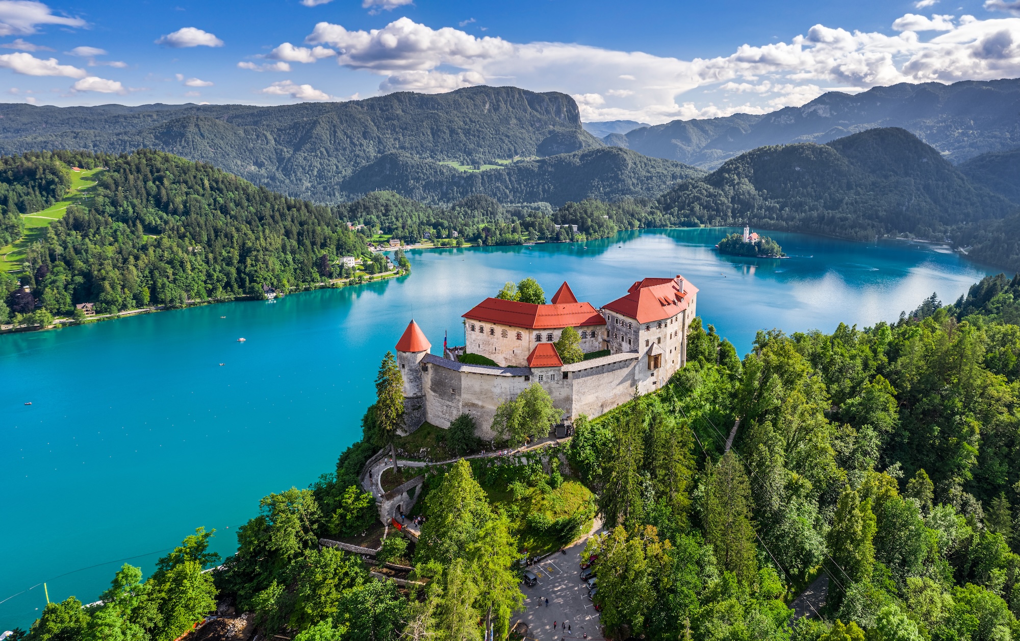 Bled, Slovenia - Aerial panoramic view of beautiful Bled Castle (Blejski Grad) with Lake Bled (Blejsko Jezero), the Church of the Assumption of Maria and Julian Alps at background on a bright summer day