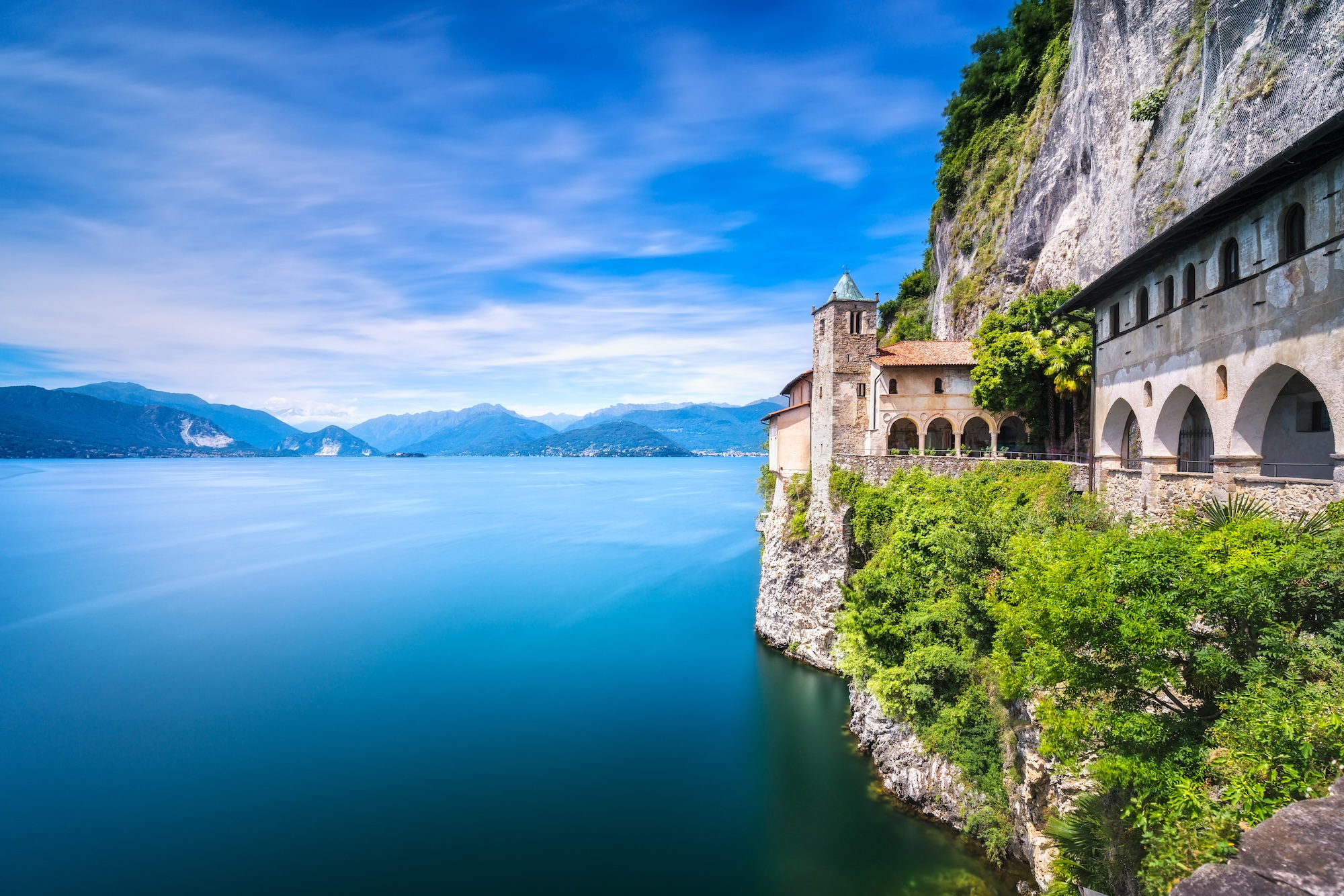 Hermitage or Eremo of Santa Caterina del Sasso medieval roman catholic monastery. Leggiuno Maggiore lake, Lombardy Italy, Europe. Long Exposure.