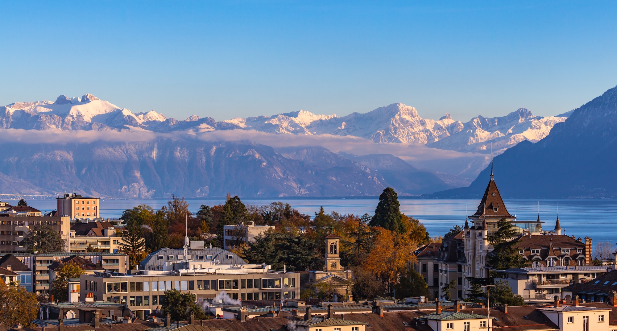 Cityscape of Lausanne with the snow covered Alps and the Leman lake in the background, Canton of Vaud, Switzerland